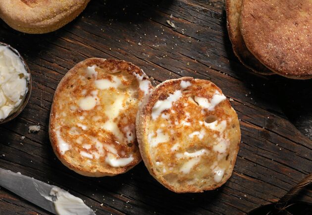  Bred rikligt med smör på ännu varma nyrostade engelska muffins.