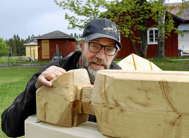  Pappa Örjan Larsson visar den knut som används i tillverkningen av timmerhusen. Den kallas Dalaknuten.
