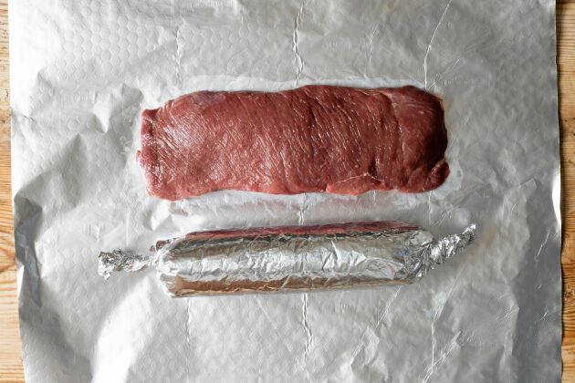 Innan den långa tillagningen formas köttet genom att viras in som en smällkaramell i ugnsfolie.