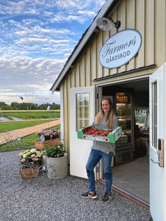  Emilia Hildingsson med en låda nyskördade jordgubbar utanför sin mycket populära gårdsbutik "Farmors gårdsbord" i Grimslöv. 